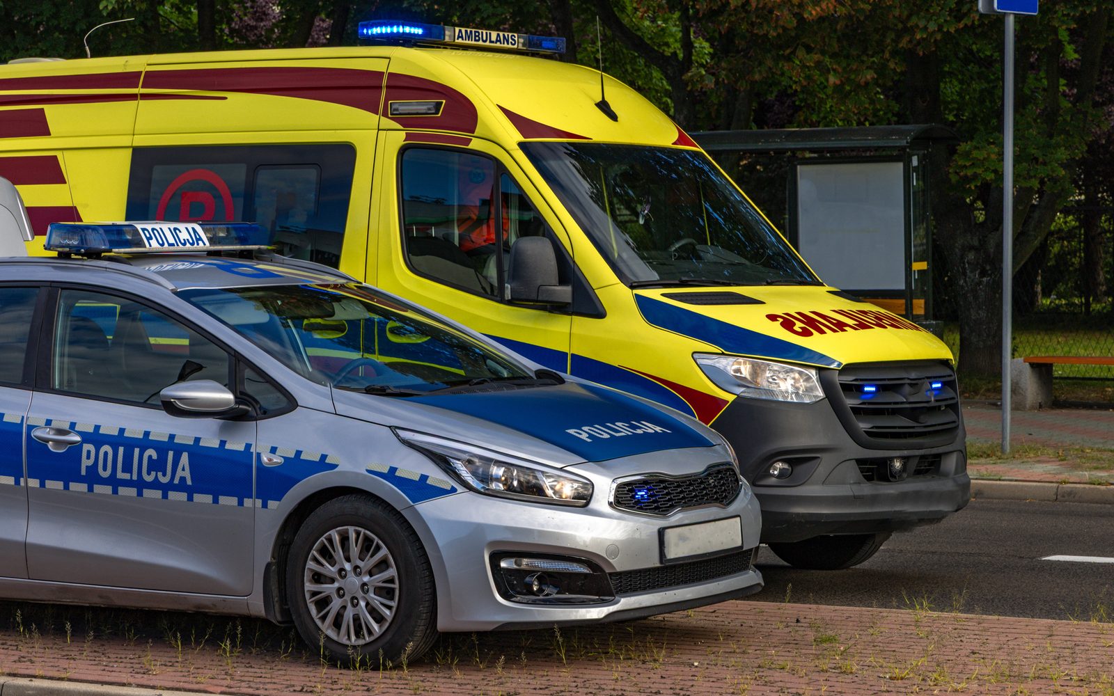 Radiowóz policji i karetka zaparkowane przy ulicy